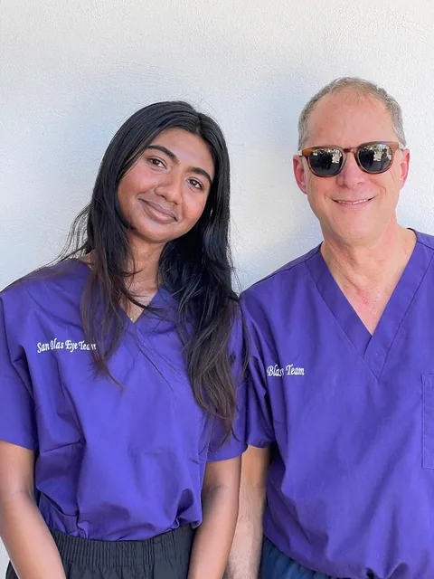 Dr. Perlman and a young volunteer in purple mission scrubs