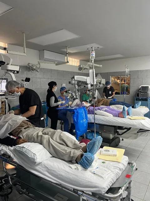 Mission operating room with patients on gurneys and surgical microscopes