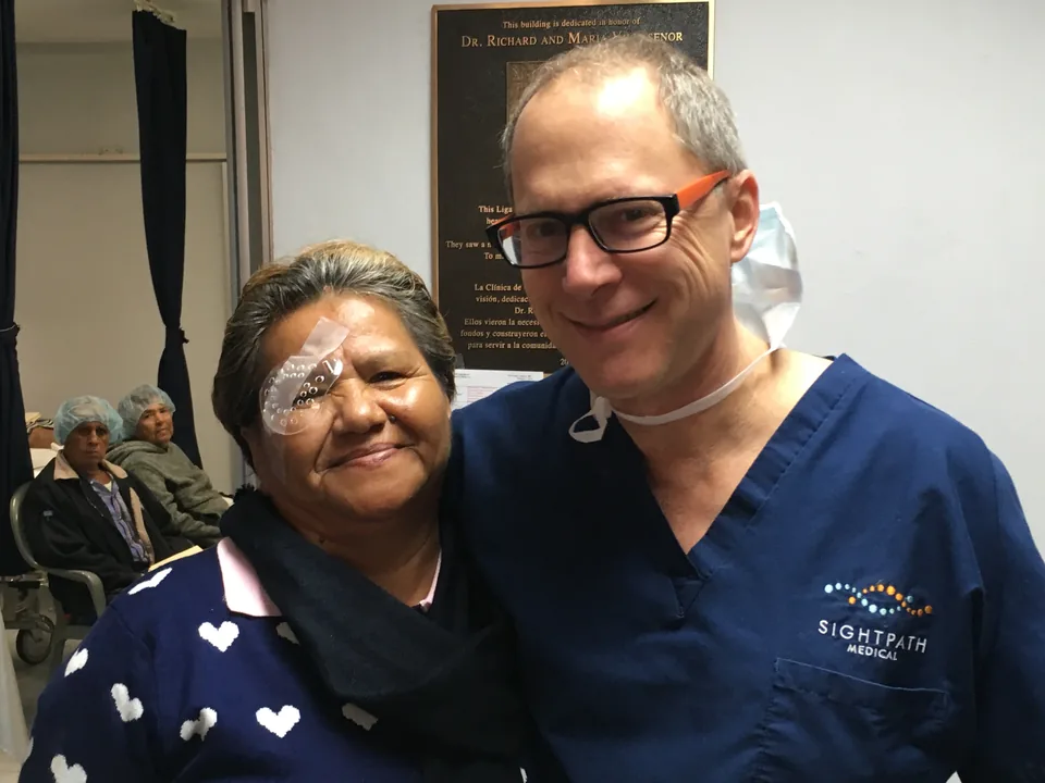 Dr. Perlman hugging a grateful patient with an eye patch after surgery